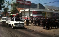 Polisi anti huru hara berjaga-jaga saat mobil yang mengangkut suporter melintas.