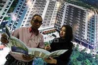 Seorang pengunjung mengecek harga apartemen yang ditawarkan.