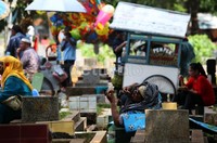 Seorang peziarah dari luar kota, tengah beristirahat di salah satu makam, saat tiba di TPU Karet Tengsin, Jakarta, Selasa (7/5).