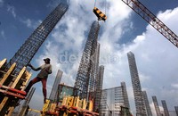 Pekerja menyelesaikan pemasangan rangka tiang pondasi.