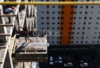 Dua orang pekerja sibuk menyelesaikan proyek pembangunan apartemen di kawasan Jakarta