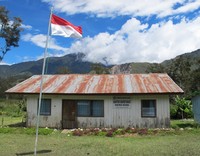 Kantor kecamatan di Distrik Maima hanya berupa bangunan kecil dari kayu. Di bagian depannya terdapat bendera Merah Putih, terus berkibar berlatar langit yang birunya tak terbantahkan (Sastri/detikTravel)