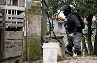 Penggerebekan dilakukan sejak siang tadi. Para terduga teroris itu melawan dengan melepaskan tembakan dan bom pipa. Seorang terduga teroris menyerah dan diamankan polisi. REUTERS/Stringer.