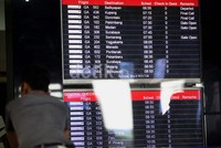 Seorang penumpang tengah mengamati jadwal penerbangan pesawat.