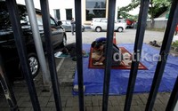 Wartawan dan petugas sholat di parkiran mobil karena musholla di dalam gedung DPP ditutup.