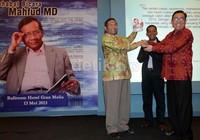 Mahfud MD menerima buku dari pihak penerbit dan perwakilan penulis.