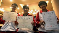 Tiga atlet muda tenis meja, tengah memperlihatkan piagam keberhasilan prestasi mereka di kejuaraan ITTF Global Junior.