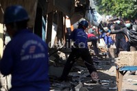 Petugas menghancurkan bangunan-bangunan tersebut dengan palu.