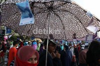 Dalam aksi demonya, seorang mahasiswi membawa payung yang ditempel dengan lembaran uang kertas.