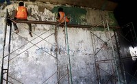Dua orang pekerja melakukan pembersihan dinding terowongan di Taman Mini, Jakarta Timur.     