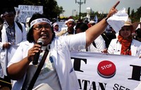 Orator meneriakkan yel-yel tuntutan di depan Istana.