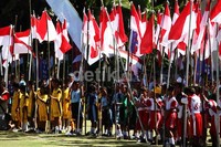 Para peserta mengikuti upacara sambil membawa bendera merah putih.