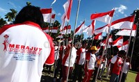 Mereka berkeliling kampung sambil mengibarkan bendera merah putih.