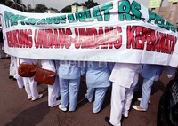 Pendemo mengusung spanduk dan poster mendukung undang-undang keperawatan.