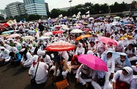 Dalam aksi tersebut para pendemo yang terdiri dari lelaki dan perempuan mengenakan baju seragam warna putih.