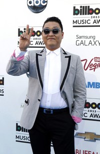 Psy tampil mengenakan jas abu-abu, kemeja putih, dan celana hitam. Reuters/Steve Marcus.