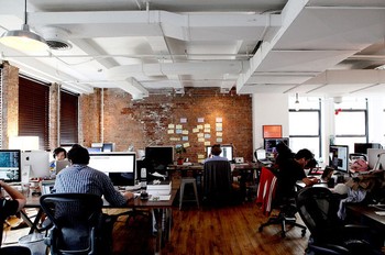     Layout meja kerja para karyawan didesain open-air. Dinding batu bata dan lantai kayunya memunculkan kesan hangat. (Credit: Elizabeth Lippman/Bloomberg)