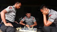 Beberapa anggot Brimob mengisi waktu dengan bermain catur.