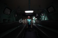 Seorang anak kecil asyik bermain dan berpose di dalam panser.