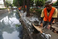 Pekerja meninggikan tanggul kali Lio yang bermuara di Kali Ciliwung di Jalan Gunung Sahari Raya, Jakarta, Minggu (26/5).