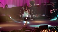 Carly Rae Jepsen tampil mengenakan tanktop dan blazer putih yang dipadukan dengan rok mini ungu bermotif hitam dan flat shoes hitam-putih.