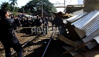 Petugas dari PT KAI dibantu oleh petugas polisi melakukan sterilisasi stasiun UI. Lamhot Aritonang/detikfoto