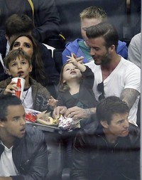 David Beckham dan putrinya Harper terlihat asyik bercanda, sementara Tom Cruise dan putranya Connor terlihat serius menonton petandingan. REUTERS/Lucy Nicholson.