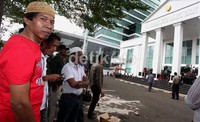 Mengenakan kaos warna merah Kiwil bergabung bersama para pendukung Hercules di halaman Pengadilan Negeri Jakarta Barat.