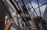 Para pekerja terlihat sedang merapihkan beberapa stand yang akan digunakan oleh perusahaan.