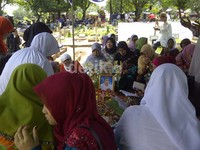 Mereka memanjatkan doa di depan makam.