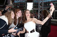 Say Cheese! Angelina Jolie meyempatkan berfoto bersama fans. Andreas Rentz/Getty Images.