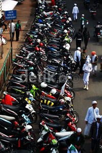 Massa memarkir motornya di jalanan sehingga menambah kemacetan.