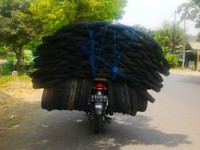 Motor bebek Suzuki Smash mengangkut beberapa ban mobil berukuran lebih besar dari bannya sendiri (Foto Andik).