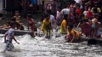 Sejumlah anak bermain di banjir Gunung Sahari Raya, Pademangan, Jakarta Utara, Jumat (14/6).