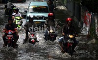 Sejumlah pengedara melintasi banjir rob di Jalan Gunung Sahari Raya.