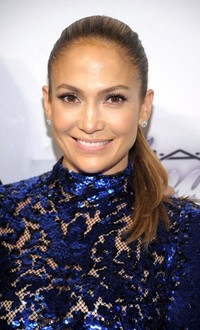 J-Lo tersenyum di depan kamera. Michael Loccisano/Getty Images/AFP.