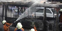 Petugas pemadam kebakaran berusaha memadamkan api yang membakar bus transjakarta. Lamhot Aritonang/detikfoto