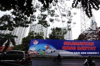 Pengendara melintas di depan baliho Selamatkan Uang Rakyat Gunakan BBM Non Subsidi!