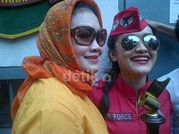 Ia tampil percaya diri dengan busana seperti pramugari berwarna merah terang dipadu dengan kacamata hitam.