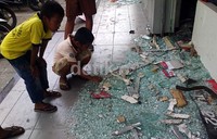 Warga menyaksikan kaca-kaca dan perlengkapan restoran yang hancur diamuk pendemo.