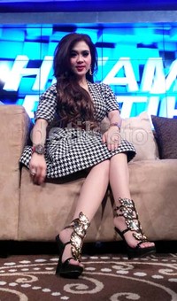 Syahrini memamerkan kaki mulusnya yang dibalut heels gold-hitam.