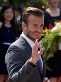 Beckham meyapa para fans saat ia tiba di Beijing, pada (17/6/2013). AFP PHOTO/Goh Chai Hin.