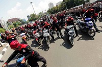 Para buruh menuntun motor dari Balaikota Jakarta ke Istana Merdeka.