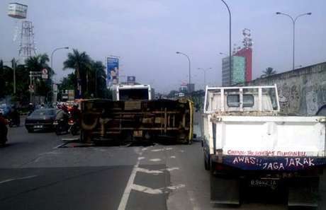 Truk Bermuatan Sirup Terbalik di Tol Meruya Arah Tomang