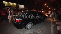 Massa menghancurkan kaca-kaca mobil tersebut.