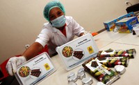Seorang pekerja menunjukkan coklat yang siap dijual. (Agus Trimukti/Humas PLN).