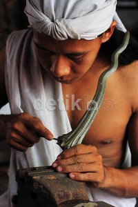 Seorang pekerja mengerjakan bagian ricikan (ragam hias) di bagian hulu bilah keris dengan teknik kikiran. Ricikan dengan istilah-istilah yang telah baku ini yang akan menjadi penentu jenis dan model keris yang diproduksi.