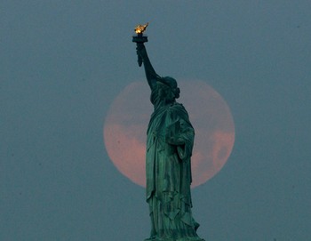     Patung Liberty juga menjadi dua kali lebih cantik saat difoto bersamaan dengan supermoon. Supermoon hanya terjadi sekali dalam tahun ini. (kredit foto: Julio Cortez/Associated Press)