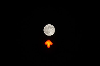Sang fotografer mengambil gambar saat posisi bulan berada di atas traffic light di downtown Roma pada tanggal 23 Juni. (kredit foto: Filippo MonteforteAFP/AFP/Getty Images)