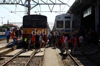 Dua buah kereta menaikkan dan menurunkan penumpang di Stasiun Bogor.